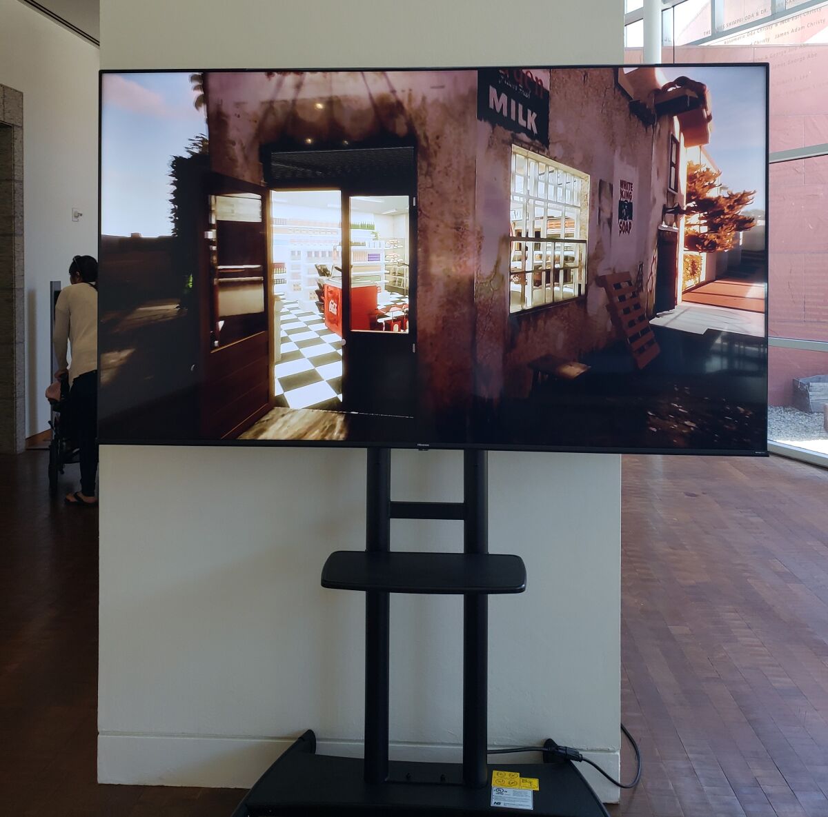 A TV at the entrance of the installation shows a fabricated video tour of long-gone Aki's Market.