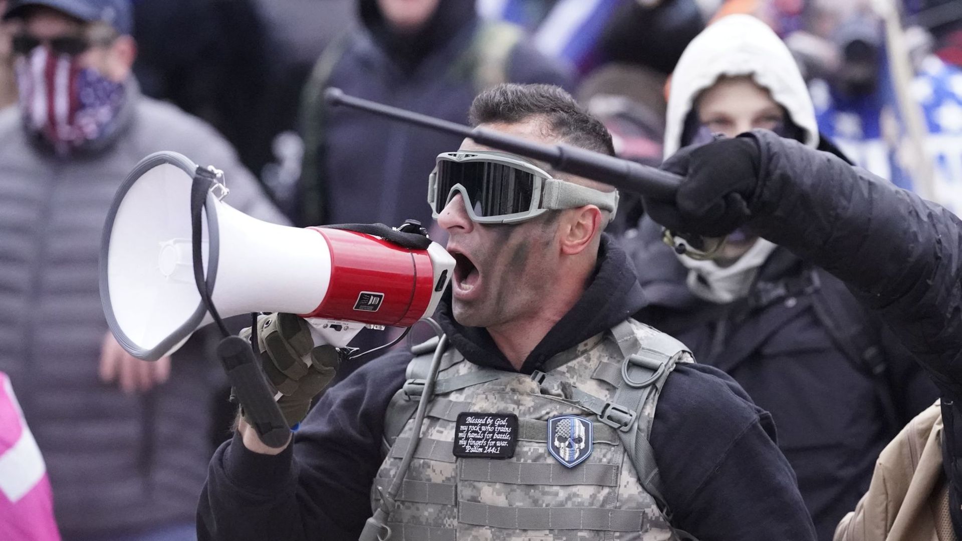 Samuel Lazar, No. 275 on the FBI Capitol Suspect list, appears here dressed in a camouflage flak jacket and black face paint and yelling into a bullhorn at the U.S. Capitol on Jan. 6, 2021. Online sleuths used his unique outfit to identify him in multiple videos where he appears to commit violent acts.