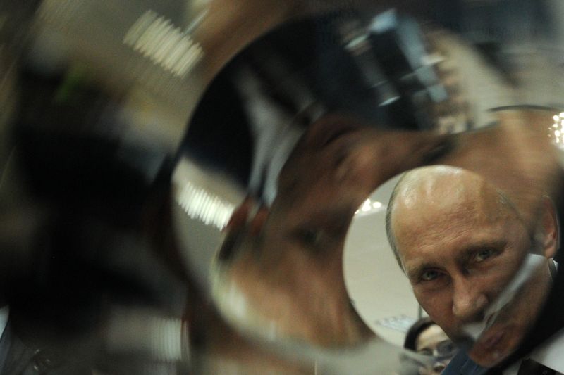 Vladimir Putin, then Russia's prime minister, looks at mirrors inside an X-ray telescope during his visit to the Russian Federal Nuclear Center.