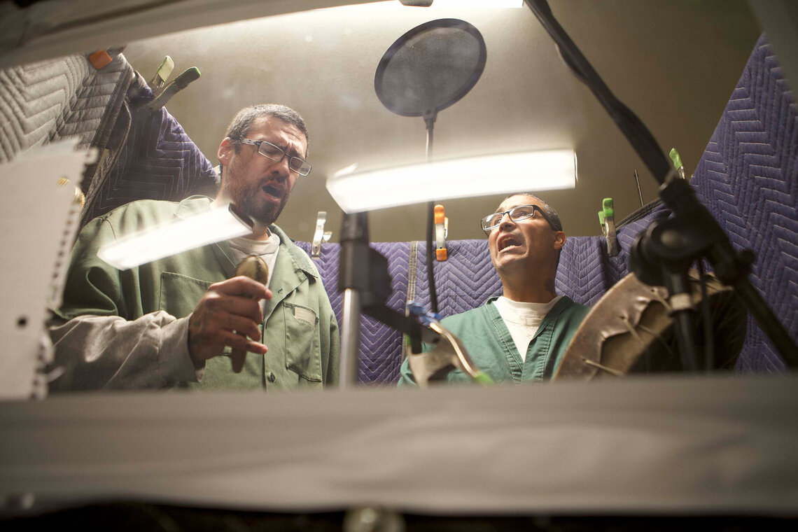 Phillip “Archi” Archuleta, left, and Gilbert “Lefty” Pacheco record music in a studio built by Die Jim Crow Records producers at the Territorial Correctional Facility in Cañon City, Colorado.