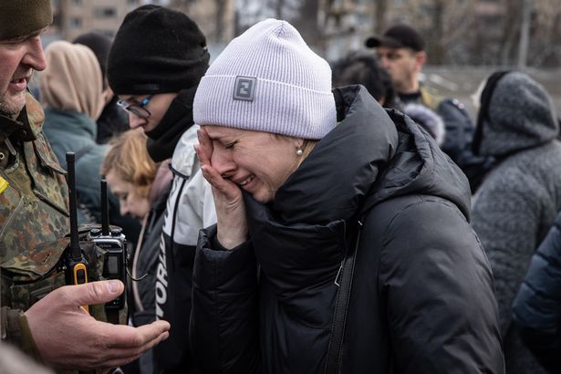 A woman cries in Ukraine after fleeing atrocities