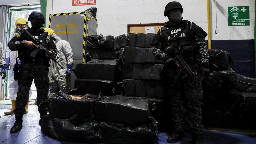 Police officers keep watch next to sacks containing cocaine packages before the incineration of more than nine tons of cocaine seized during different operations, according to the Ecuador's Interior Ministry, in a warehouse at an undisclosed location, in Ecuador April 21, 2022.