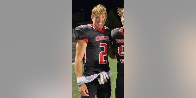 Jordan DeMay smiling in uniform on football field