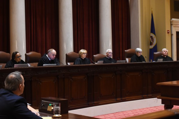 A row of judges behind a bench in a courtroom. 