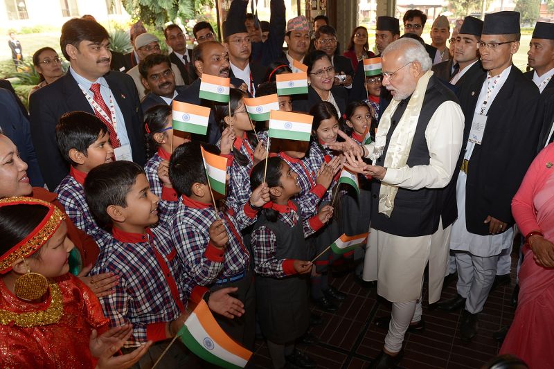 Indian Prime Minister Narendra Modi greets children waving Indian flags as he arrives in Kathmandu, Nepal, for a summit.