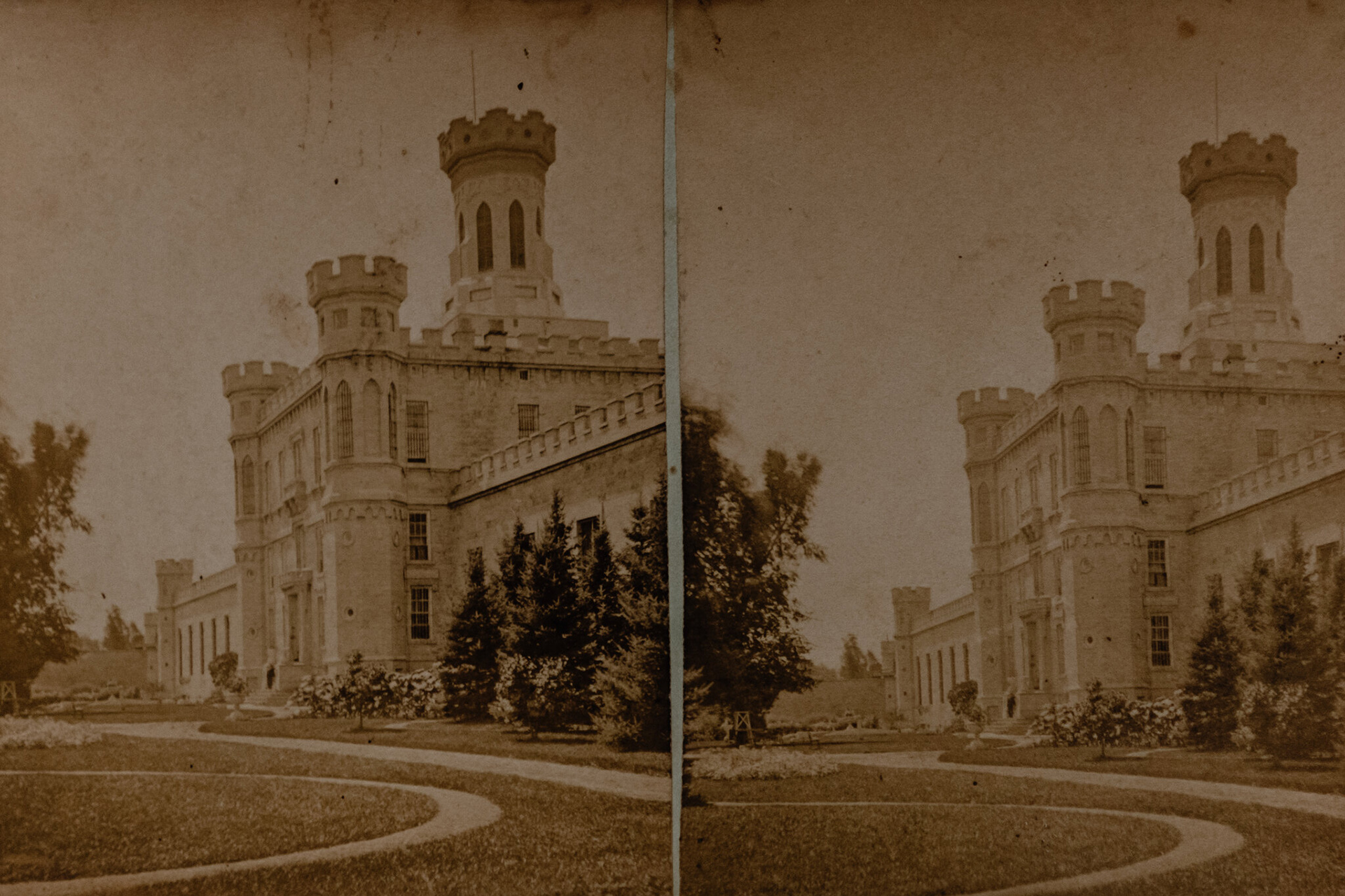 Two sepia-toned photos of a stone masonry building with crenelated walls and towers are arrayed side-by-side to serve as the basis of a stereograph image.