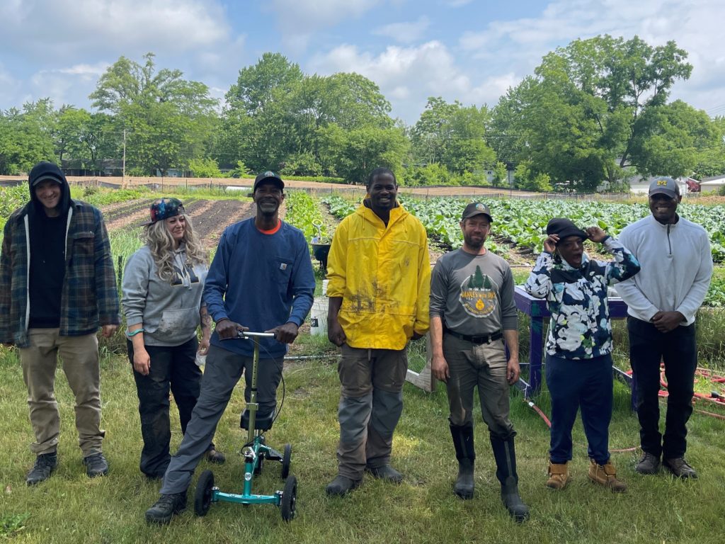 Members of the 2023 team at We the People Opportunity Farm pose in Ypsilanti Township, Michigan. From left to right: Korey Deiter, Heidi Hoffman, Melvin Parson, Donte Smith, Eric Kampe, Destiny Moore, Stephanale Adams. Photo courtesy of We the People Opportunity Farm
