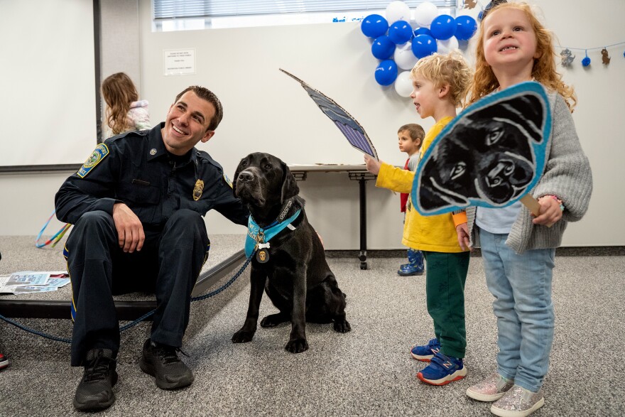 K-9 Hodges and Officer Eric Fredericks pose for a photo at Hodges’ birthday party, which the local library had thrown in his honor. Hodges often visits the library, where children who need encouragement with their reading have the opportunity to read to him.