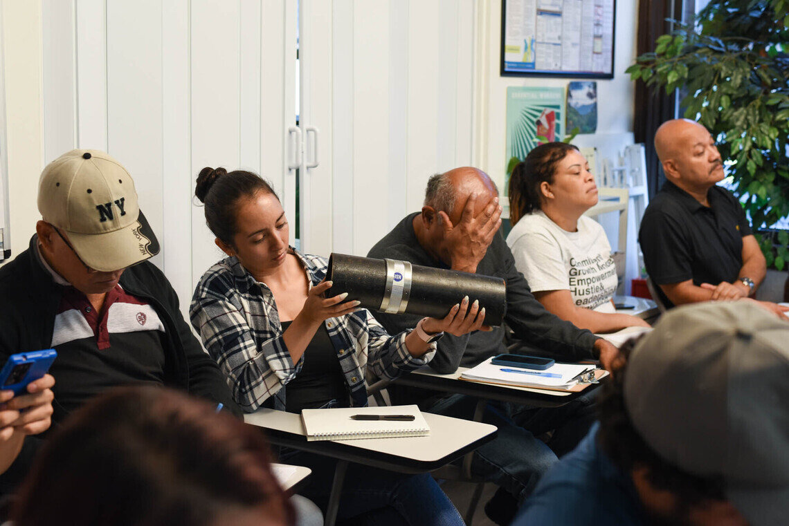 Workshop participants examine pipes during the class.