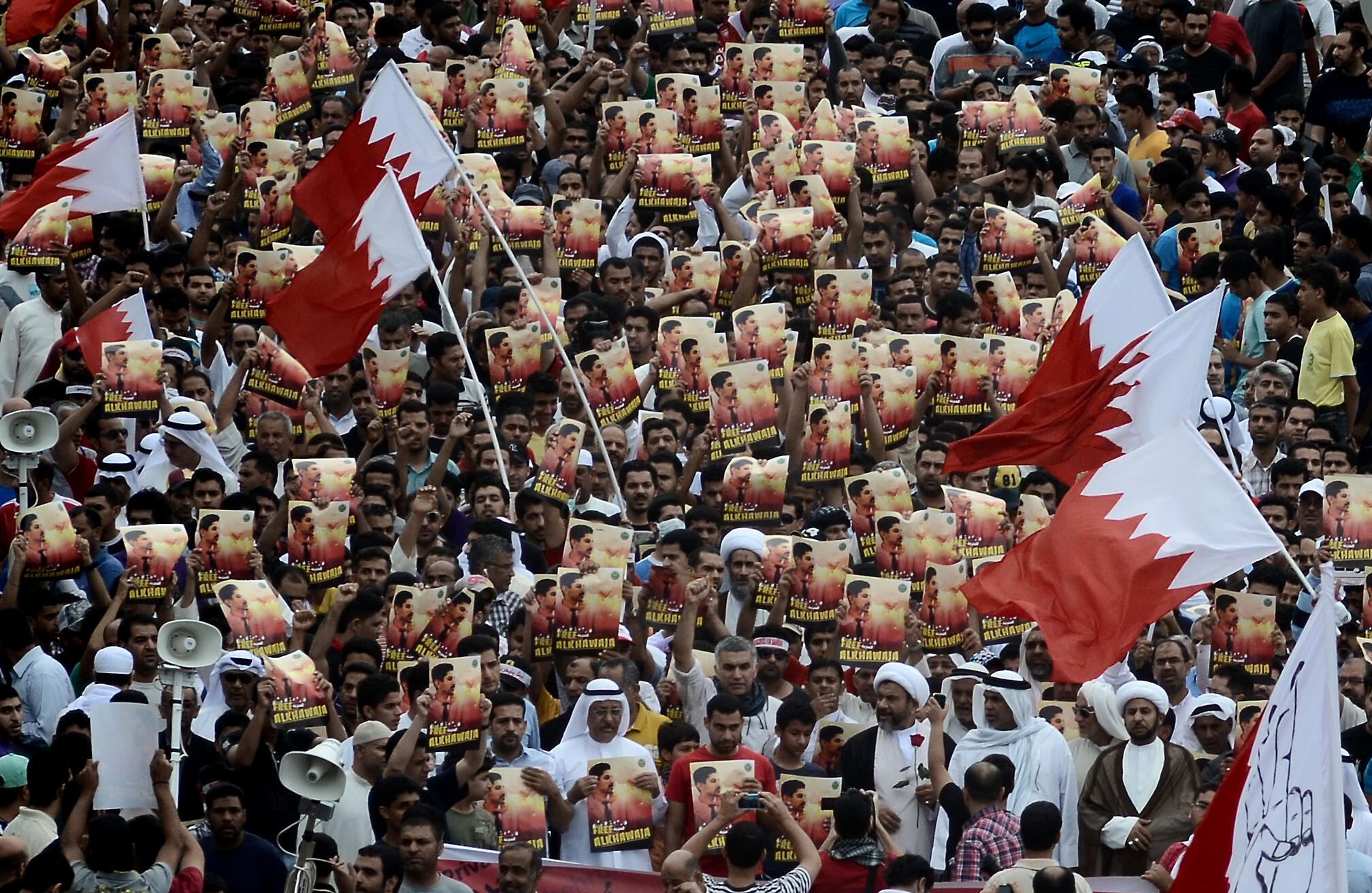 Bahraini Shiite demonstrators holding posters of Abdulhadi al-Khawaja during a protest in 2012