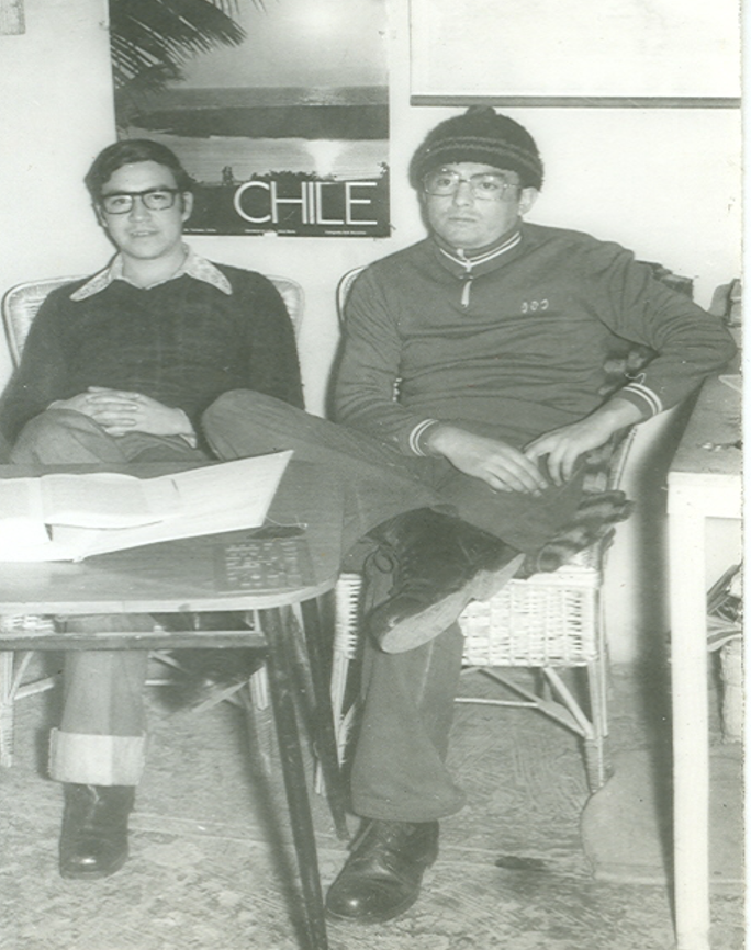 A black and white photo of two men, seated side by side