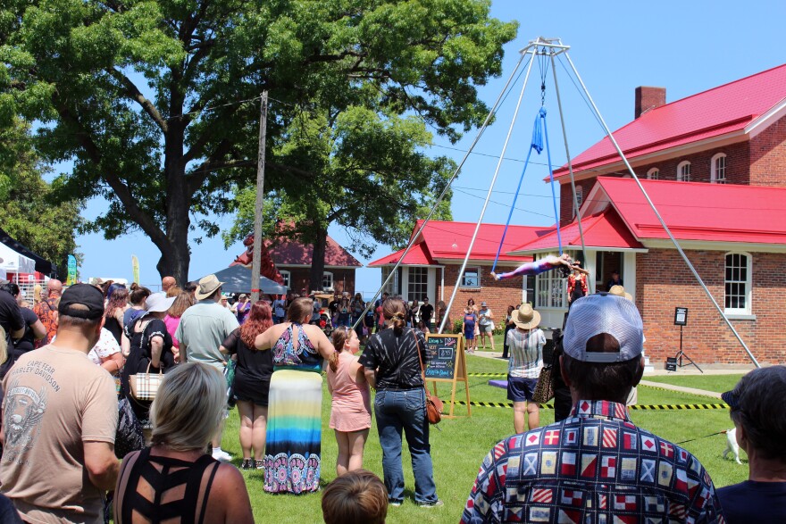 A crowd gathers to watch an aerial performer for the performance art troupe, D3 circus. 