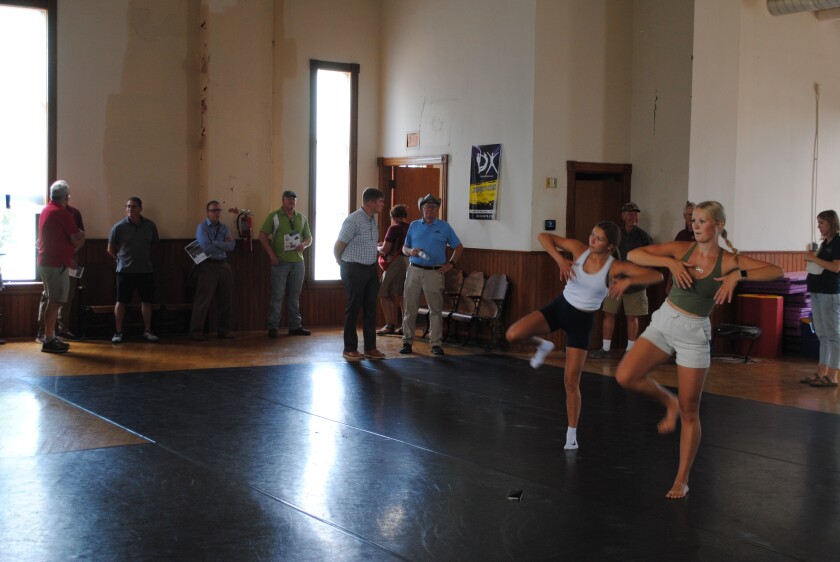 Participants in a Revitalize Appleton tour visit the upstairs Opera House of the historic Appleton City Hall and Opera House while students in the Valley Dance District rehearse on July 25, 2023.