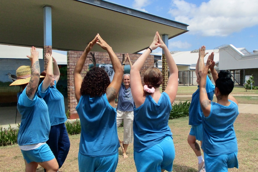 A yoga teacher takes some women through their yoga poses.