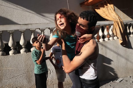 A man carries a rescued Palestinian girl from the rubble of a building after an Israeli airstrike at the Rafah refugee camp in the southern Gaza Strip.