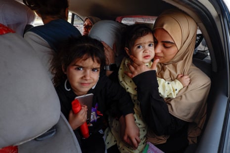 Palestinian woman Raghda Abu Marasa, who fled to the southern part of Gaza, sits in a car with her children and family members in Khan Younis