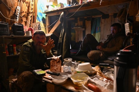 Ukrainian service personnel rest inside a dugout in Donetsk.