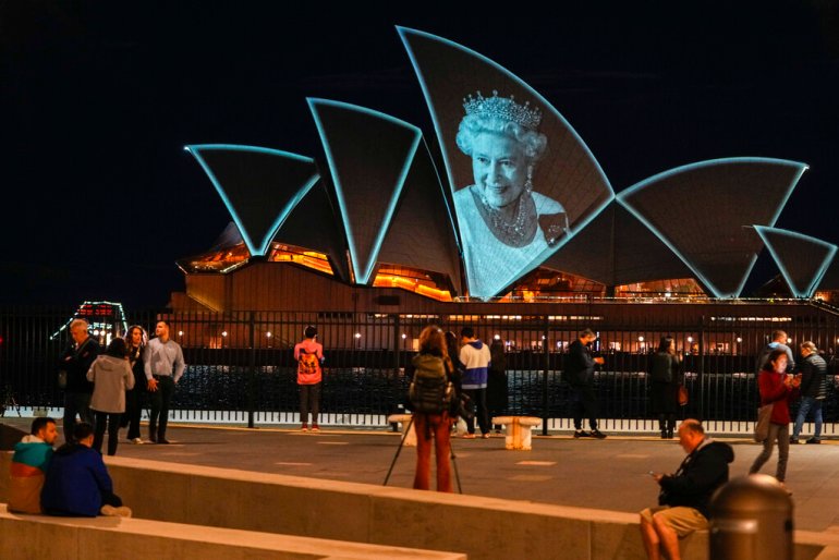 an image of queen elizabeth's face is projected on the sydney opera house