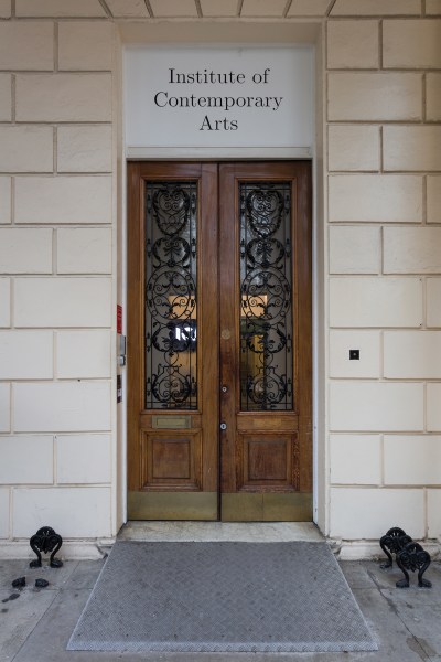 Mahogany doors with wrought iron embelleshments below a sign that says 