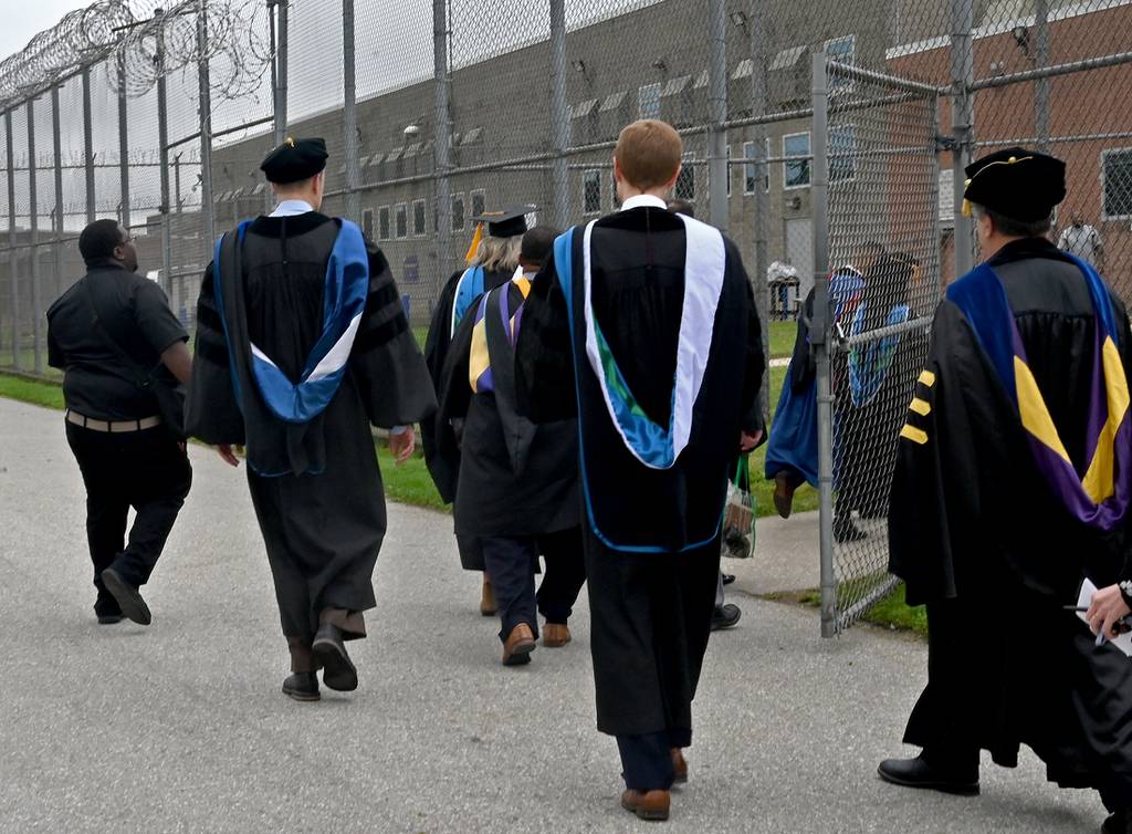 Faculty and administrators from the University of Baltimore walk toward a building at Jessup Correctional Institution to attend the Second Chance commencement on Oct. 6, 2023.