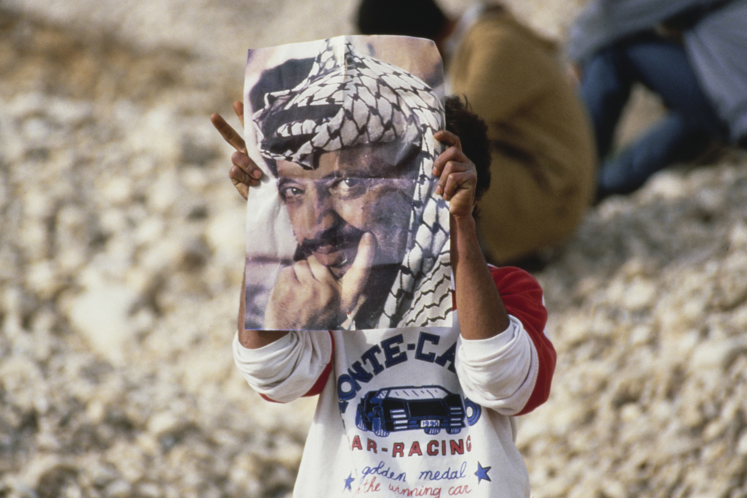 A child holds up a portrait of PLO leader Yasser Arafat during the First Intifada.