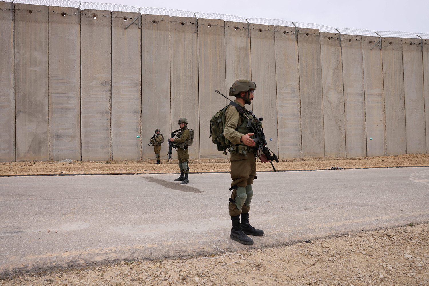 Israeli soldiers stand guard by the fence along the border with the Gaza Strip in southern Israel.