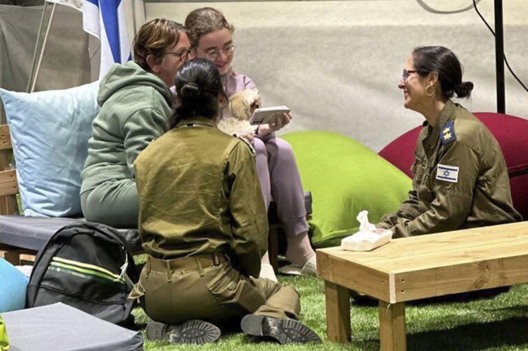 This handout photo provided by GPO shows Gabriela and Mia Leimberg, rear, talking with family from a meeting point in Israeli territory after being released by Hamas, Tuesday, Nov. 28, 2023. (GPO/Handout via AP)