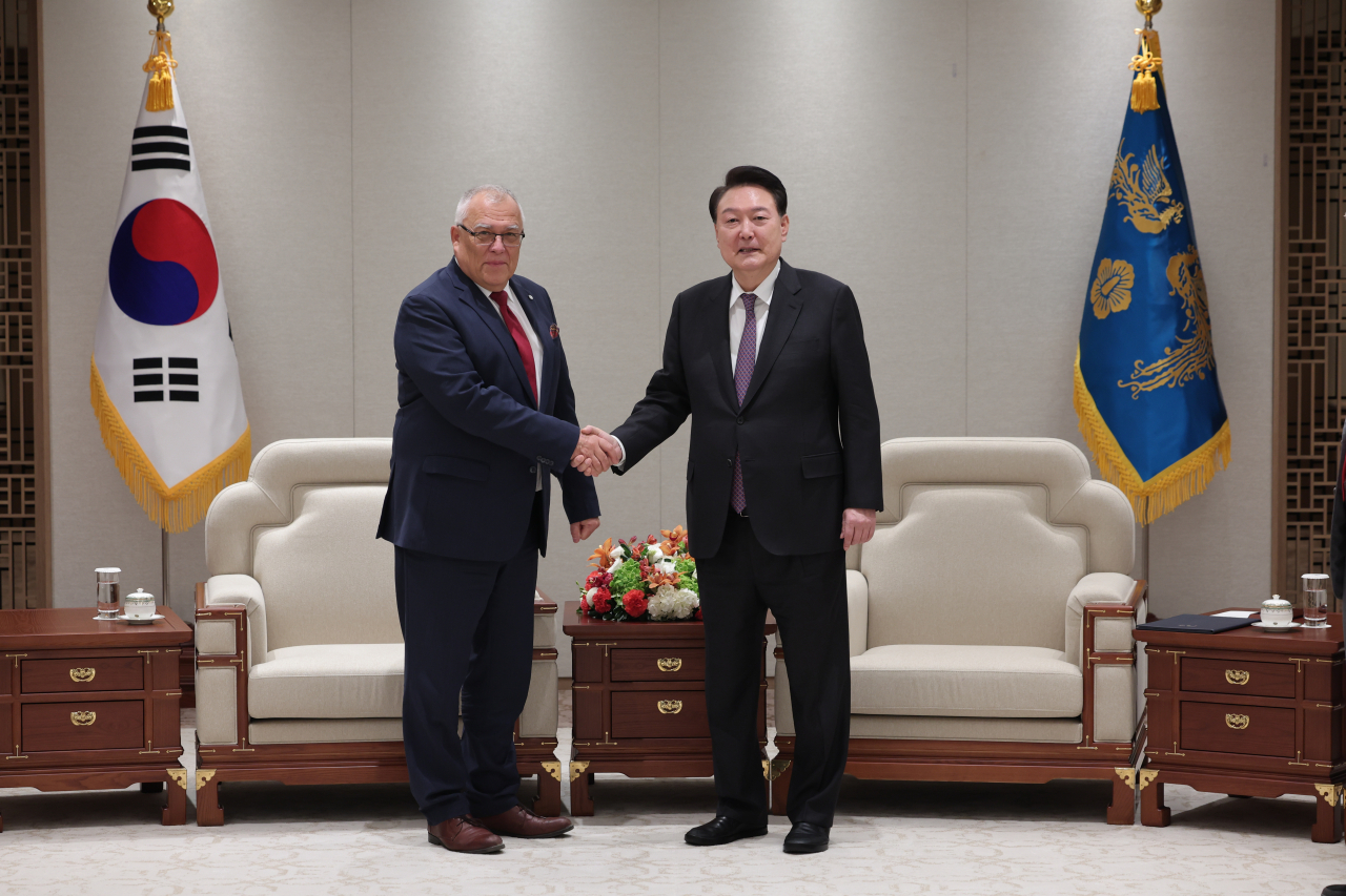 President Yoon Suk Yeol (right) shakes hands with Piotr Hofmanski, chief of the International Criminal Court, ahead of their meeting at South Korea's presidential office in Seoul on Monday, in this photo provided by Yoon's office. (Yonhap)