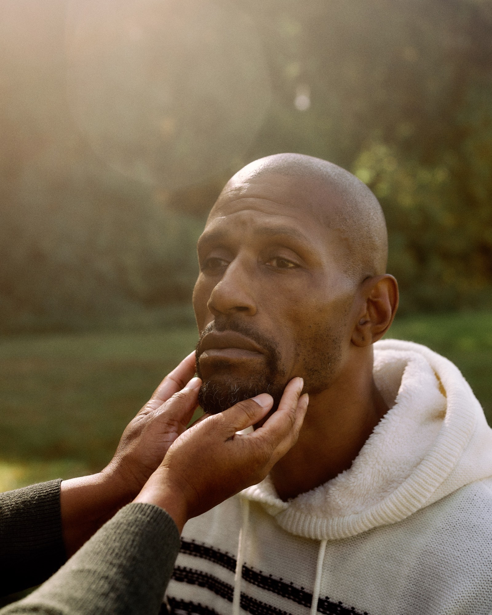 Carronne Jones touches the face of Alonzo Sawyer with two hands.