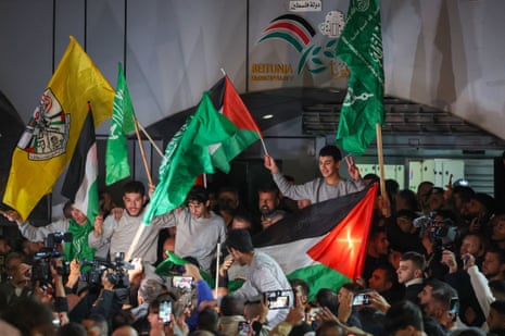 Palestinian prisoners (wearing grey jumpers) cheer after being released from the Israeli Ofer military facility in Baytunia in the occupied West Bank.