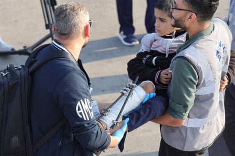 Volunteers transport a wounded Palestinian child off the plane upon their arrival in Abu Dhabi on November 18, 2023, after being evacuated from Gaza as part of a humanitarian mission organised by the United Arab Emirates.