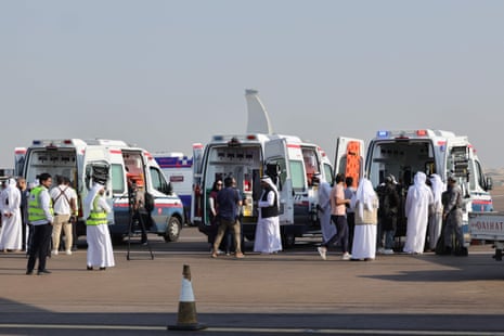 Volunteers and ambulances wait on the tarmac in Abu Dhabi on November 18, 2023, upon the arrival of the plane carrying evacuated Palestinians from Gaza as part of a humanitarian mission organised by the United Arab Emirates.