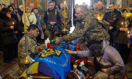 Relatives, friends and comrades gather around the coffin of Ukrainian serviceman Maksym Petrenko.