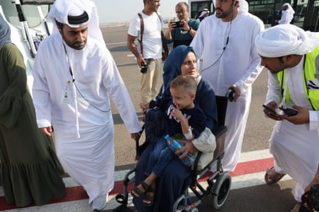 Emiratis speak with a Palestinian mother carrying her child their arrival in Abu Dhabi on November 18, 2023, after being evacuated from Gaza as part of a humanitarian mission organised by the United Arab Emirates.