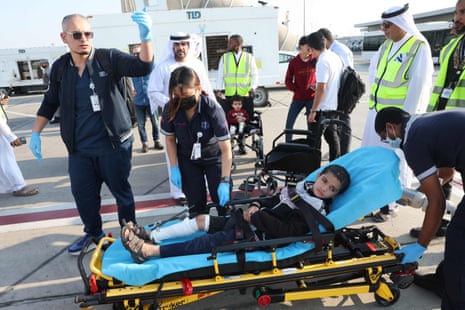 Volunteers transport a wounded Palestinian child off the plane upon their arrival in Abu Dhabi on November 18, 2023, after being evacuated from Gaza as part of a humanitarian mission organised by the United Arab Emirates.