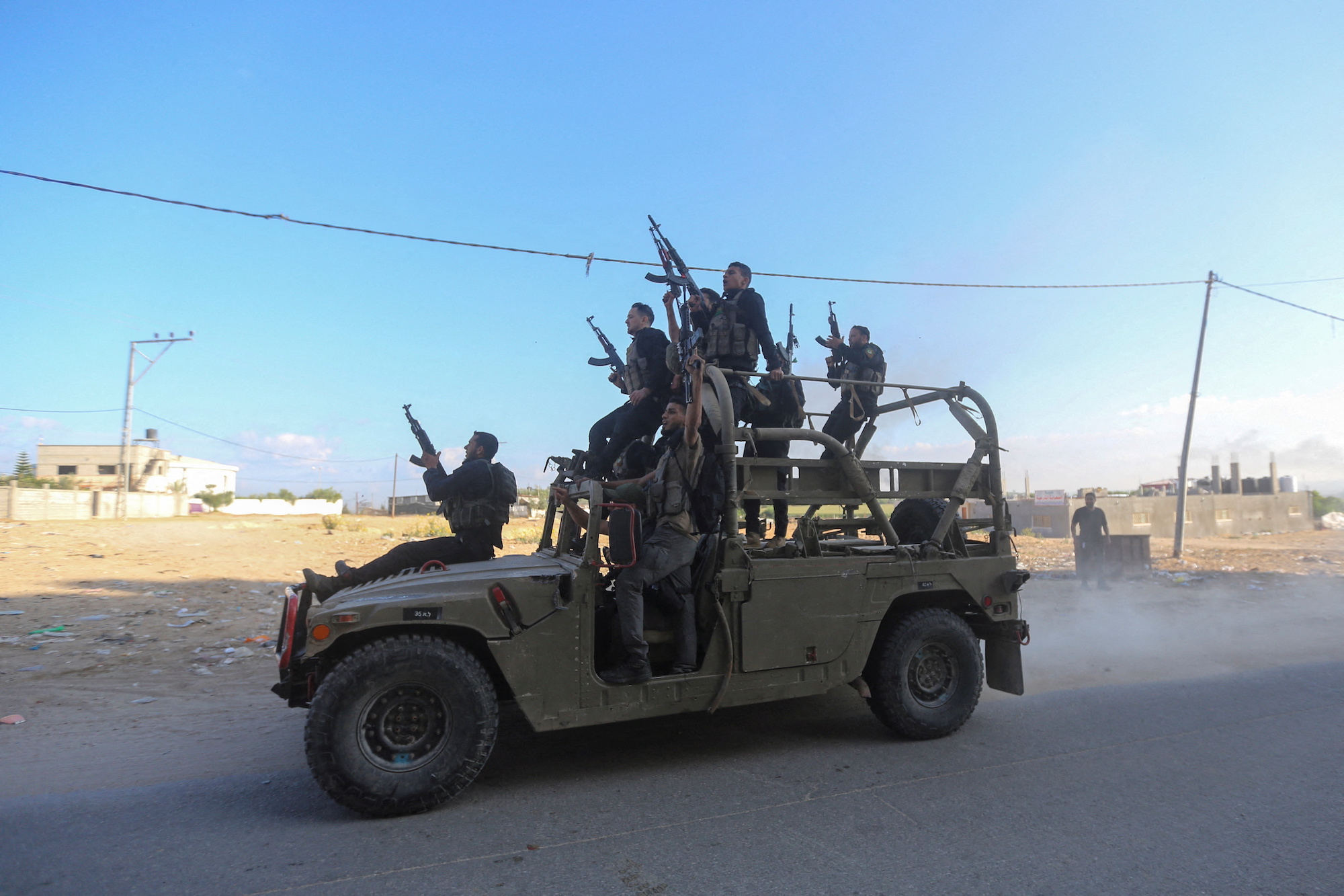 Palestinian militants ride an Israeli military vehicle that was seized by gunmen who infiltrated areas of southern Israel on October 7.