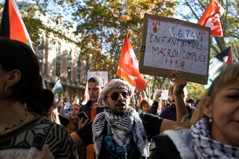 A man reacts with a placard reading '4,674 children killed, Macron accomplice'. Thousands of people desmonstrated in Toulouse, France in support of Gazans, the Gaza Strip and more generally for Palestine on November 18, 2023.