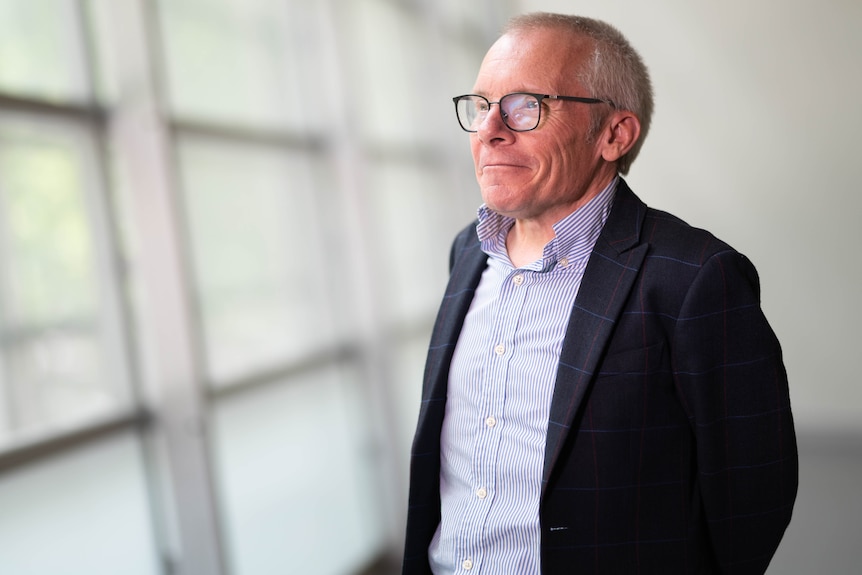 Portrait of a man in glasses in a brightly lit room