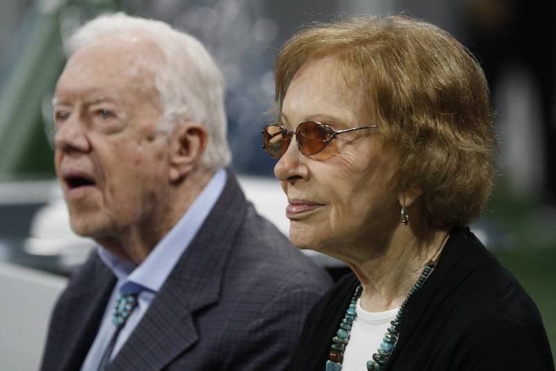 An older man and woman sit next to each other.