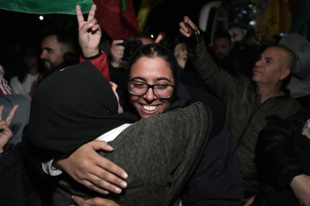 Palestinian prisoner Fairuze Salameh is greeted after she was released, in the West Bank town of Ramallah, early Wednesday Nov. 29, 2023. Hamas and Israel released more hostages and prisoners under terms of a fragile cease-fire that held for a fifth day Tuesday. (AP Photo/Nasser Nasser)