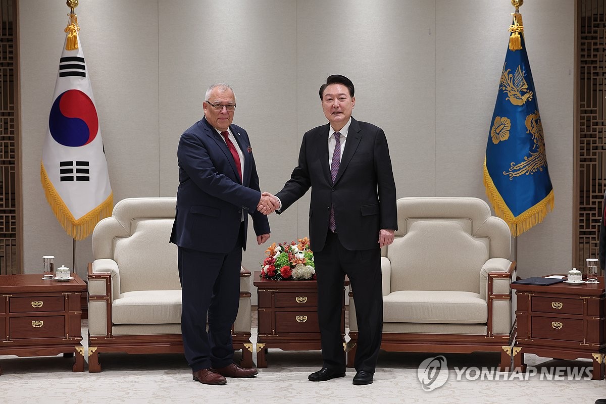 President Yoon Suk Yeol (R) shakes hands with Piotr Hofmanski, chief of the International Criminal Court, ahead of their meeting at South Korea's presidential office in Seoul on Nov. 13, 2023, in this photo provided by Yoon's office. (PHOTO NOT FOR SALE) (Yonhap)