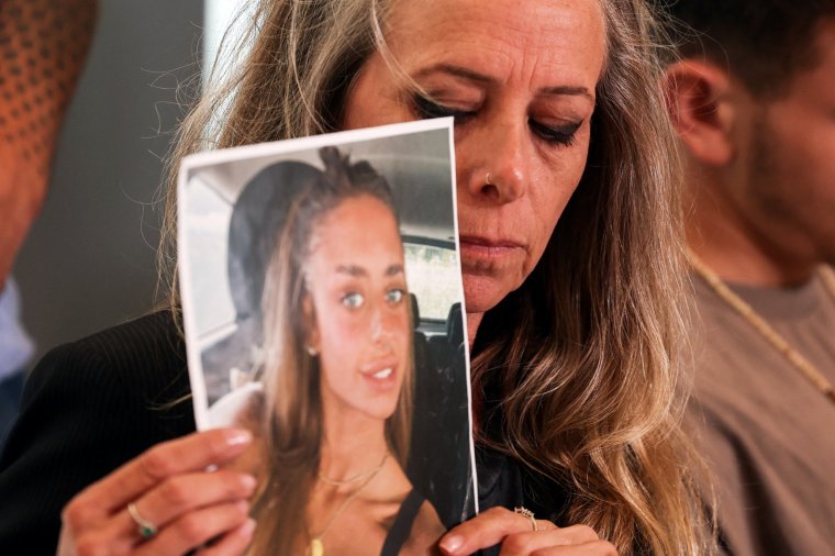 The mother of Maya Schem holds up a picture of her daughter who was kidnapped into the Gaza Strip, following a deadly infiltration by Hamas gunmen from Gaza, in Tel Aviv, Israel, October 17, 2023. REUTERS/Ronen Zvulun