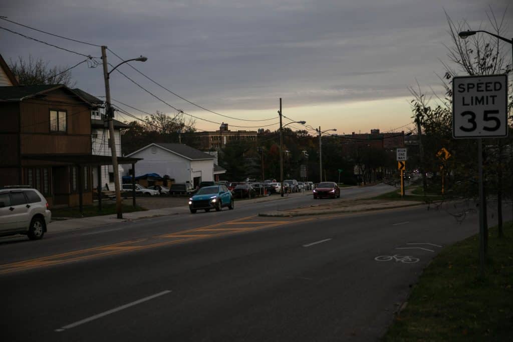 Cars drive through the intersection of West Exchange Street in Akron during twilight.