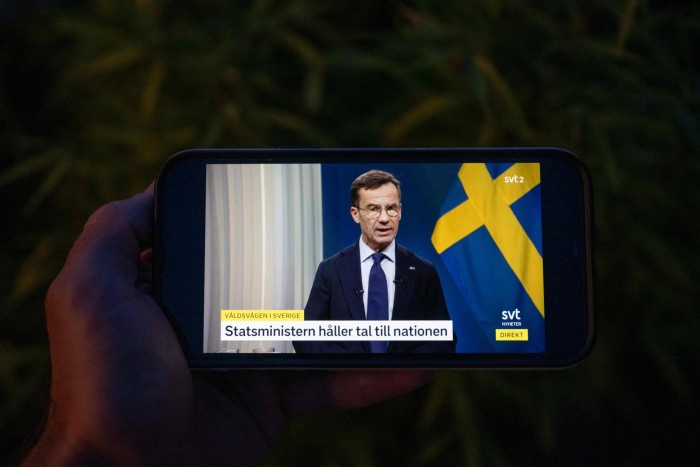 A photo of Swedish Prime Minister Ulf Kristersson on television as he addresses the nation