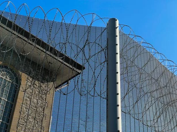 Barbed wire surrounding an old cell block