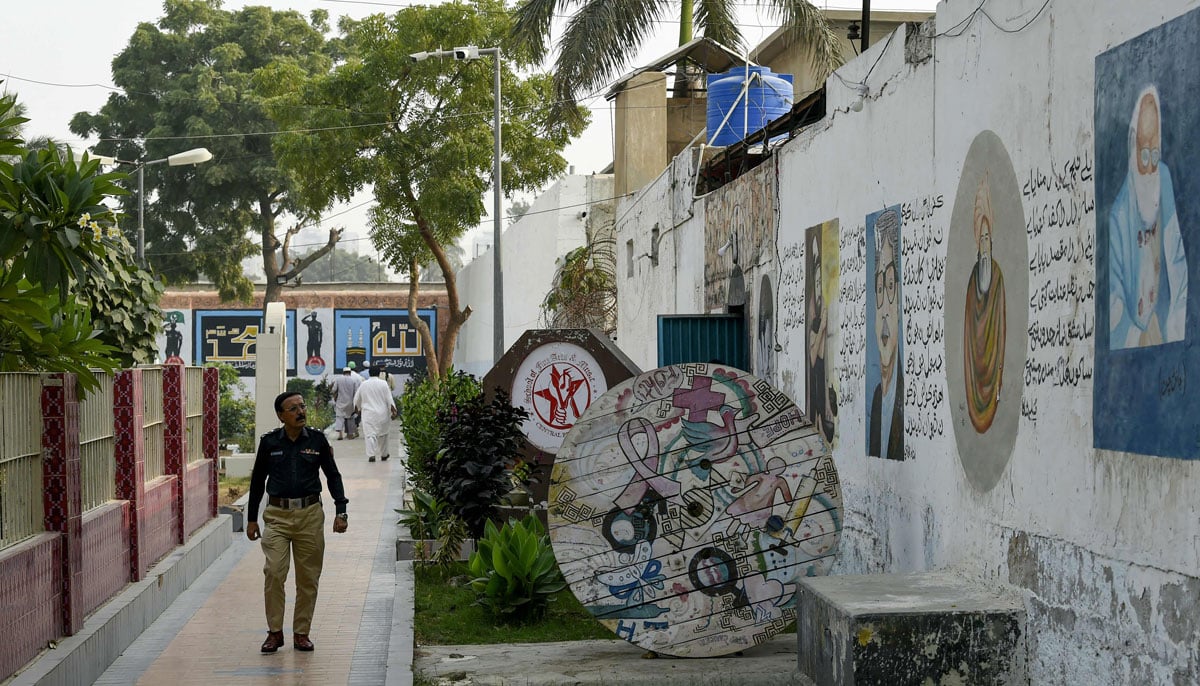 A police officer looks at a wall laden with artworks by prisoners, at the central jail in Karachi on December 16, 2023. — AFP