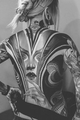 A detailed, realistic black and white back tattoo on a woman.