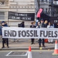 Activists hold an anti-fossil fuels banner during a demonstration as Cop28 begins in London, on 30 November 2023.