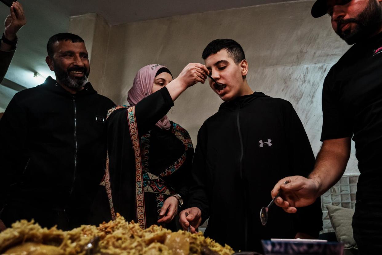 Sahar feeds her son Ahmad Salaymah, 14, home-cooked makluba after he was released from prison