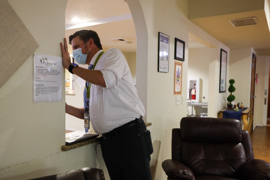 Director Mark Tittle chats with a resident in the dining area on the other side of the wall Thursday, Nov. 16, 2023, at the Tarrant County Mental Health Jail Diversion Center in Fort Worth.